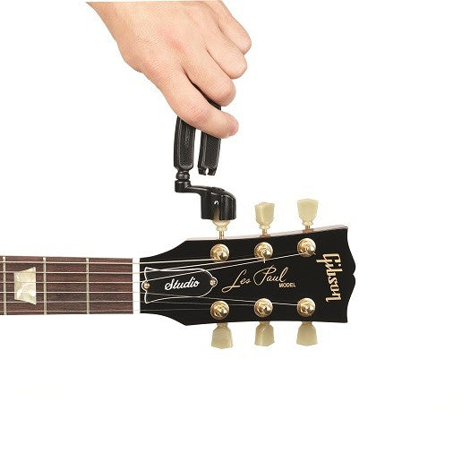 Hand using a black string winder and cutter on a guitar headstock