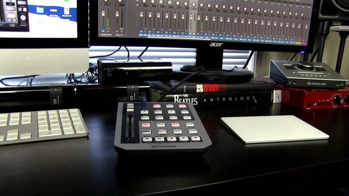 Black studio fader controller on desk with colorful button panel and display